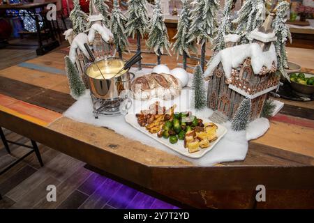 A selection of Christmas food used for a festive fondue including sprouts and pigs in blankets surrounded by festive Christmas decorations on a wooden Stock Photo