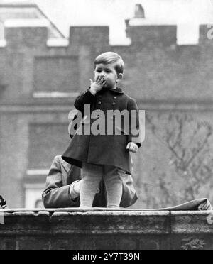 Prince Charles blows a Kiss Supported by his nurse on the wall of Clarence House (London home of Princess Elizabeth), Prince Charles blows a kiss to the crowds today.  The Royal procession - with the King and Queen driving in the Irish State coach - had just passed Clarence house on the return journey from the Houses of Parliament to Buckingham Palace.  The King and Queen and Princess Elizabeth had attended the State opening of Parliament.  31 October 1950 Stock Photo