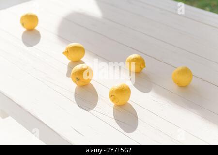 Some yellow ripe lemons on a white wooden table Stock Photo