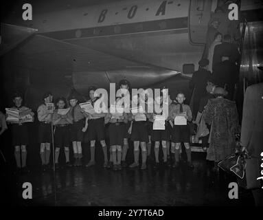 AIRBOURNE ON WINGS OF SONG   Christmas carols give an unusual send-off to the passengers boarding a New York - bound Stratocruiser of B.O.A.C. at London Airport . The singers are from the 71st Kensington and 20th Fulham Air Scouts .     18 December 1950 Stock Photo