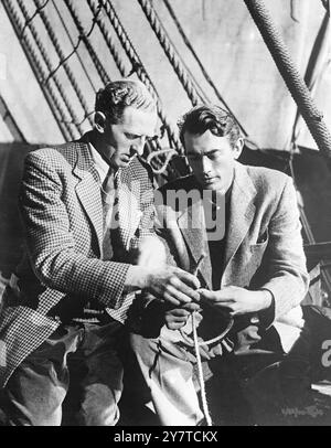 CAPTAIN GREGORY TIES THE BOW-LINE    Fastidious movie-star, who likes to learn all the details of his current role, is Gregory Peck of Hollywood, California, here to play the lead in the new film ' Captain Horatio Hornblower '.  teaching him the intricacies of the bow-line -- a knot used often by sailors of the British Navy in Nelson's time.  With him is commander I.T. Clark, R.N.(retired) (left).   He is technical adviser for the film, which tells the story of a British Navy captain .  21 March 1950 Stock Photo