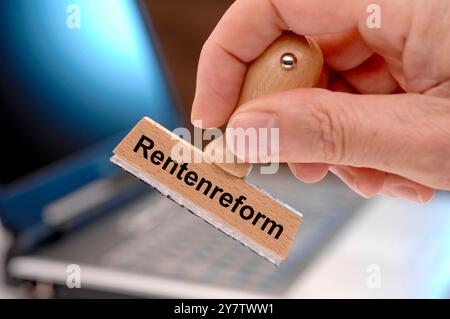 Stempel mit der Aufschrift Rentenreform Ein Holzstempel ist beschriftet mit dem Aufdruck: Rentenreform *** Stamp with the inscription pension reform A Stock Photo