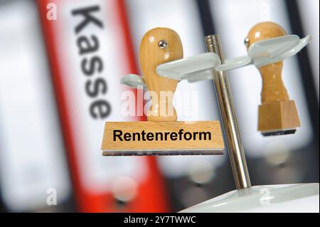 Stempel mit der Aufschrift Rentenreform Ein Holzstempel ist beschriftet mit dem Aufdruck: Rentenreform *** Stamp with the inscription pension reform A Stock Photo