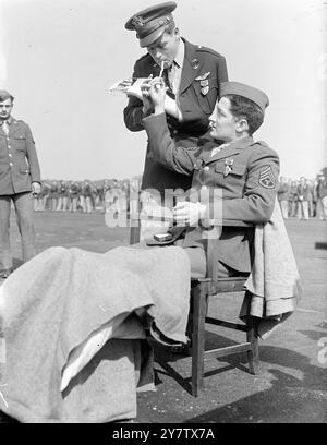 US ARMY AIR FORCE HEROES DECORATED IN ENGLAND. Major General Carl Spaatz, Commanding the US Air Force in the European theatre of Operations, visited an operational station in England, presenting awards to twenty three officers and men for distinguished service during operation over enemy occupied territory. Photo Shows: Sergeant Frederick rich (in chair), of Erie, Pennsylvania, who received the Order of the Purple Heart, and who was wounded in a daylight bombing attack on the shipyards at Le Trait, France, enjoying a cigarette after the ceremony, with First Lieutenant Eugene M Lockhart, from H Stock Photo