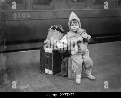 A LITTLE REFUGEE FROM SINGAPORE ARRIVES IN LONDON Four hundred refugees from Singapore and Malaya have just arrived in London. Some of them had made their escape from Malaya in two American battleships which took them to Colombo.  Photo Shows: Little Janice Murray, from Singapore, with her luggage on arrival at a London station.  15 April 1942 Stock Photo