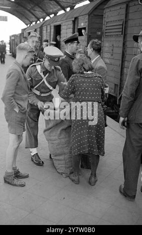 BRITISH MILITARY POLICE IN GERMANY SWOOP ON CROSS FRONTIER TRAINS FOR BLACK MARKET OPERATORS. - - Passenger trains to and from Holland and Belgium are frequently searched at Krefeld Station, Germany, by British Military Police and German Police for black market operators and their stock in trade. - Small scale operators who have been a few miles into the country to barter cigarettes and similar luxuries for a few vegetables are not troubled. - In the course of the search shown in these pictures, a Belgian soldier was caught with between 40 and 50 pounds of coffee, worth about £400 on the black Stock Photo