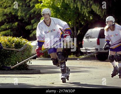 Mountain View, California:   A system administrator and asoftware engineer with Google play roller hockey in the company parking lot. Google is promoting a healthier lifestyle by having weekly hockey games and serving healthier food in the company cafeteria.  May 3, 2001. Stock Photo