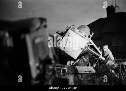 George Hole, one of Britain's best known astronomers, pictured with a telescope he made himself rigged in the back garden of his home at Patcham, Sussex, England. While the world is looking at the first man on the moon on television Mr Hole is hoping to catch a glimpse of the rocket flares as the lunar module of Apollo XI went down to the moon's surface at the Sea of Tranquility.The moon can be seen next to the chimney of Mr. Holes house.21 July 1969 Stock Photo