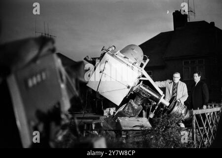 George Hole, one of Britain's best known astronomers, pictured with a telescope he made himself rigged in the back garden of his home at Patcham, Sussex, England. While the world is looking at the first man on the moon on television Mr Hole is hoping to catch a glimpse of the rocket flares as the lunar module of Apollo XI went down to the moon's surface at the Sea of Tranquility.The moon can be seen next to the chimney of Mr. Holes house.21 July 1969 Stock Photo