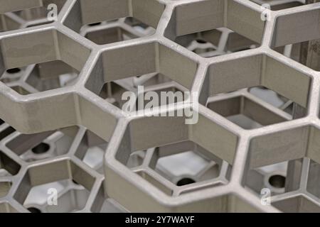 Openwork three-dimensional metal grid with hexagonal cells. Close up shot, abstract metalwork industry background. Stock Photo