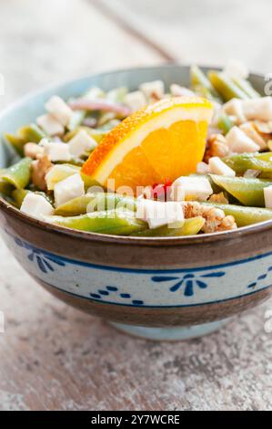 Bowl with a green bean and walnut salad with soy cheese pieces. Stock Photo