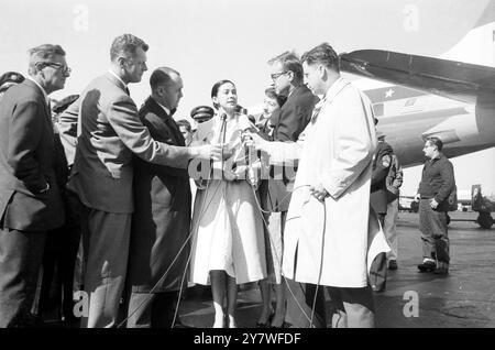 Newsmen with microphones , crowd around ballerina Dame Margot Fonteyn as she arrives at New York from Miami . Dame Margot freed from jail in Panama City flew into New York with her lips sealed . She declined to say whether she had anything to do with the alleged plot against the Panamanian Government , and denied knowledge of the whereabouts of her husband , Robert Arias , whom Panama wants to arrest for revolutionary activities . 23 April 1959 Stock Photo