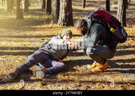 Black guy helping his injured friend while camping Stock Photo