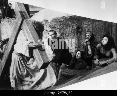 Jesus carries his cross to Calvary in the epic movie Ben Hur.Charlton Heston in the title role looks on. The face of Christ is never seen. November 1959 Stock Photo