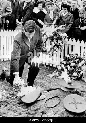 Washington :  Senator Edward Kennedy kneels as he places a small bunch of flowers on the grave of his brother, November 22nd.The second anniversary of the assassination of the late President John F . Kennedy .  November 1965 Stock Photo