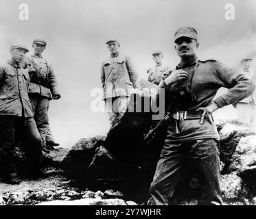 With the last armed confrontantion over , the Indian soldier in the foreground has a restrained smile as he moved close to Communist Chinese troops along the Sikkim - Tibet border . The large rock seperating the soldiers apparently marks the border . 18 January 1968 Stock Photo
