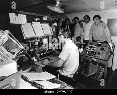 Disc jockeys of the pirate radio ship , Radio Caroline North pictured in the studio of the vessel .  Left to right , in rear , Dee Harrison ; Don Allen ; Wally Mechan ; Madic Sloane ; Jimmy Gordon and Martin King (seated)  1st September 1967 Stock Photo