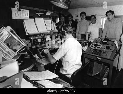 Dis jockeys of the pirate radio ship , Radio Caroline North pictured in the studio of the vessel .  Left to right , in rear , Dee Harrison ; Don Allen ; Wally Mechan ; Madic Sloane ; Jimmy Gordon and Martin King (seated)  1st September 1967 Stock Photo