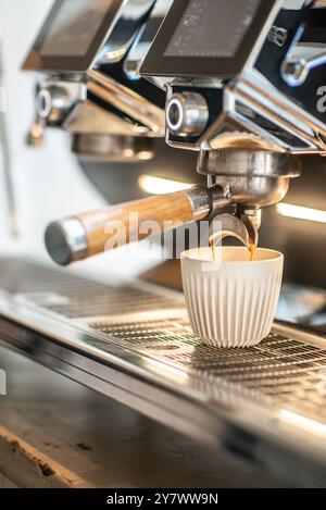 Coffee extraction from a professional coffee machine. Espresso machine making fresh coffee. Coffee shop. Stock Photo