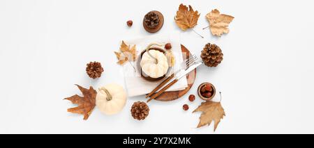 Autumn table setting with pumpkins and dried leaves on white background Stock Photo