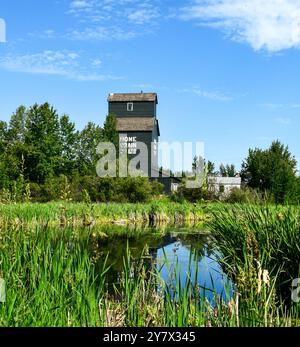 Wooden Cabins  and a cattle farmer surrounded by nature and a lake at Ukrainian Heritage Village in Canada, on a sunny day Stock Photo