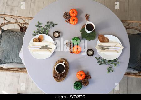Autumn table setting with pumpkins, burning candles and leaves Stock Photo