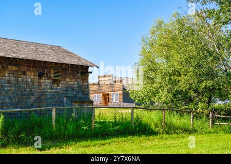 Wooden Cabins surrounded by nature at Ukrainian Heritage Village in Canada, on a sunny day Stock Photo