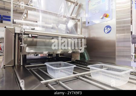 Automatic industrial machine for plastic packaging food. shaft of an automated packaging line with plastic film. Food industry Stock Photo