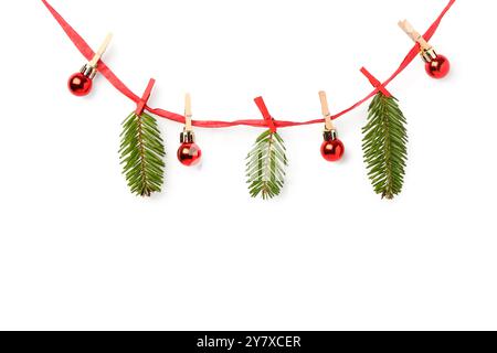 Ribbon with Christmas tree branches, balls and clothespins on white background Stock Photo