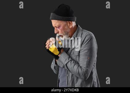 Mature homeless man with cup on dark background Stock Photo