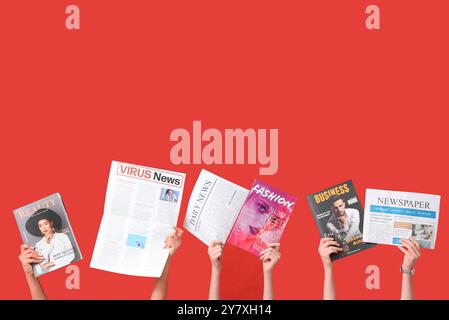 Female hands with different magazines and newspapers on red background Stock Photo