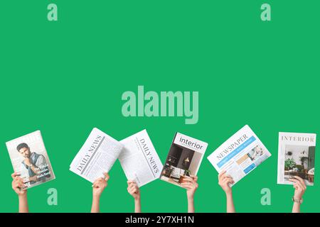 Female hands with different magazines and newspapers on green background Stock Photo