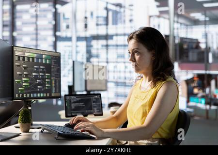 Programmer creating complex machine learning models that can process and analyze vast amounts of data to improve and automate decision making processes. Woman programming in office Stock Photo