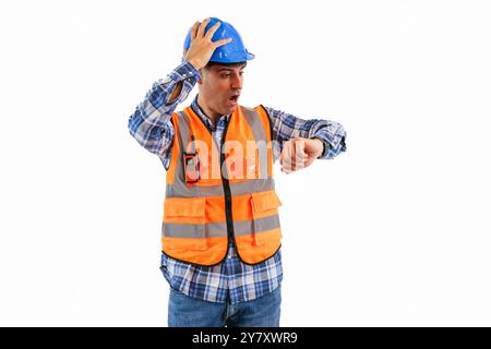 engineer, dressed in an orange reflective vest and a safety helmet, is anxiously holding his head while glancing at his wristwatch. This image capture Stock Photo
