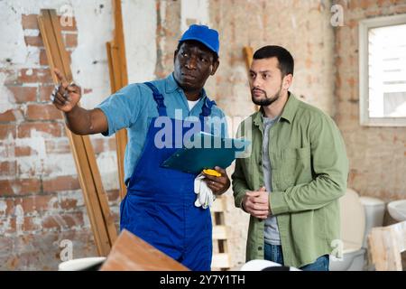 Builder having conversation with designer about working plan Stock Photo