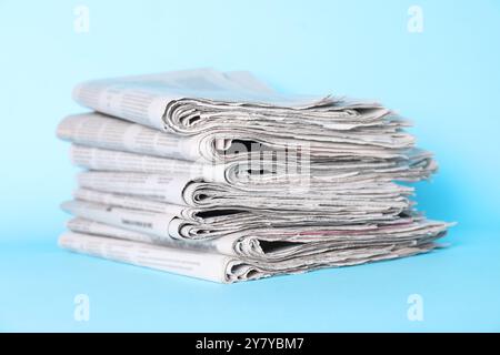 Stack of newspapers on light blue background Stock Photo