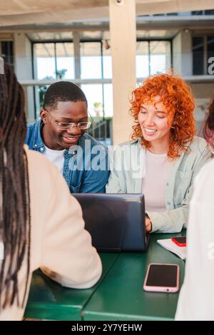Vertical. Two Multiracial Teenage Students Smiling While Learning the Lesson and Preparing for an Exam in the University Campus Library. Young Classmates Reading Notes Doing High School Homework. High quality photo Stock Photo