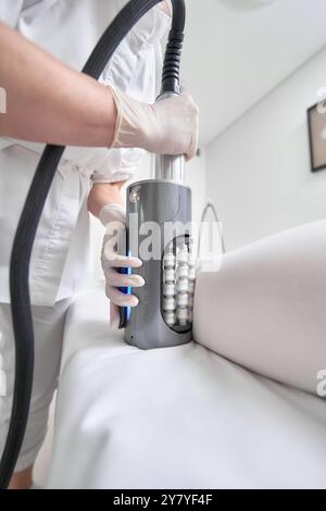 Aesthetic technician performing body contouring treatment in clinic Stock Photo