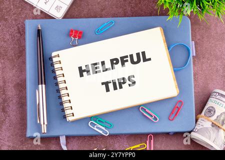 Helpful Tips words in a notebook in a composition with office supplies, top view Stock Photo
