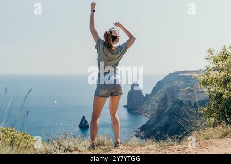 Woman Celebrating on a Clifftop with Ocean View Stock Photo