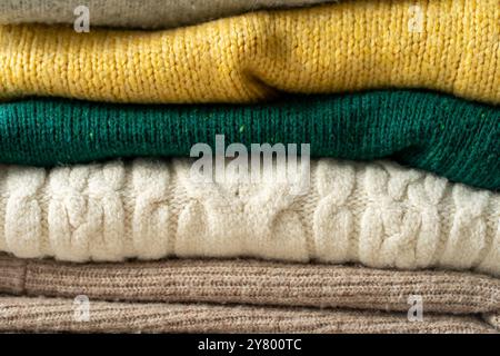 A stack of knitted sweaters on the table. Background textures. Stock Photo
