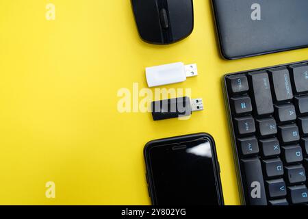 keyboard, mouse, smartphone and flasdisk on yellow background Stock Photo