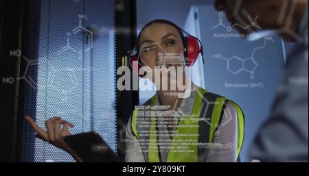 Image of data processing and chemical formula over diverse workers in server room Stock Photo