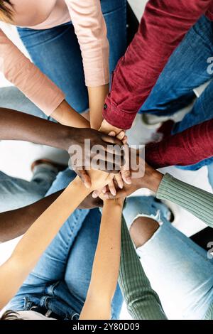 Young group of diverse people stacking hands Stock Photo