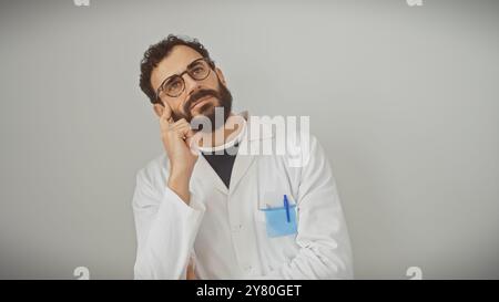 Thoughtful middle-aged male scientist in lab coat pondering against a white background Stock Photo
