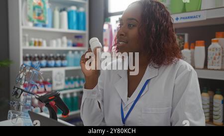 Woman pharmacist standing in a well-stocked pharmacy, holding a medicine bottle and scanning items with a barcode reader Stock Photo