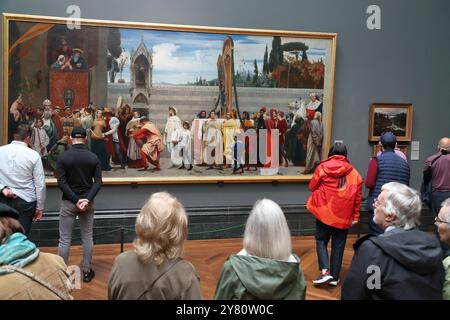 Visitors study Cimabue's Celebrated Madonna by Frederic, Lord Leighton at the National Gallery, London, UK Stock Photo