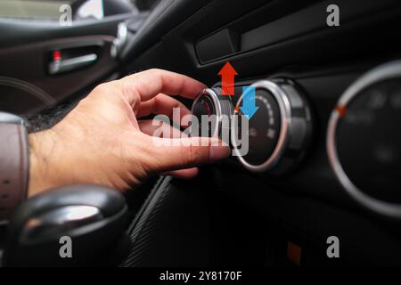 Adjusting the temperature of air conditioning inside a car , The driver uses his hands to turn the knob to adjust the air conditioning temperature whi Stock Photo
