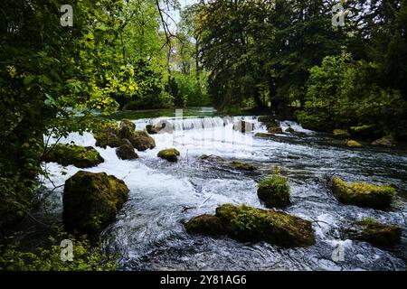 Munich, Germany - April 18, 2024: Waterfall on a stream in the Englischer Garten, english garden park Stock Photo