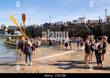 Pilot Gig crews carrying their oars waiting to board their Pilot Gigs for Women's Newquay County Championships Cornish Pilot Gig Rowing event at Newqu Stock Photo